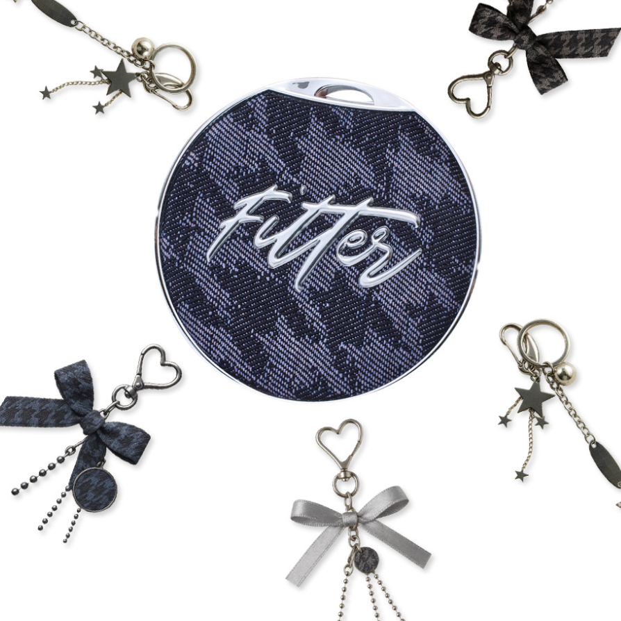 Round fabric with "fittér" text, surrounded by decorative keychains with bows and stars.