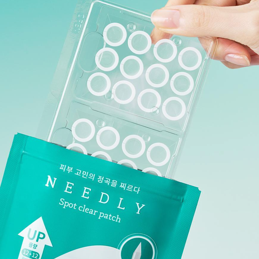 Hand holding NEEDLY Patch Spot Clear 12 Patches packaging against teal background, showcasing the acne treatment patches.