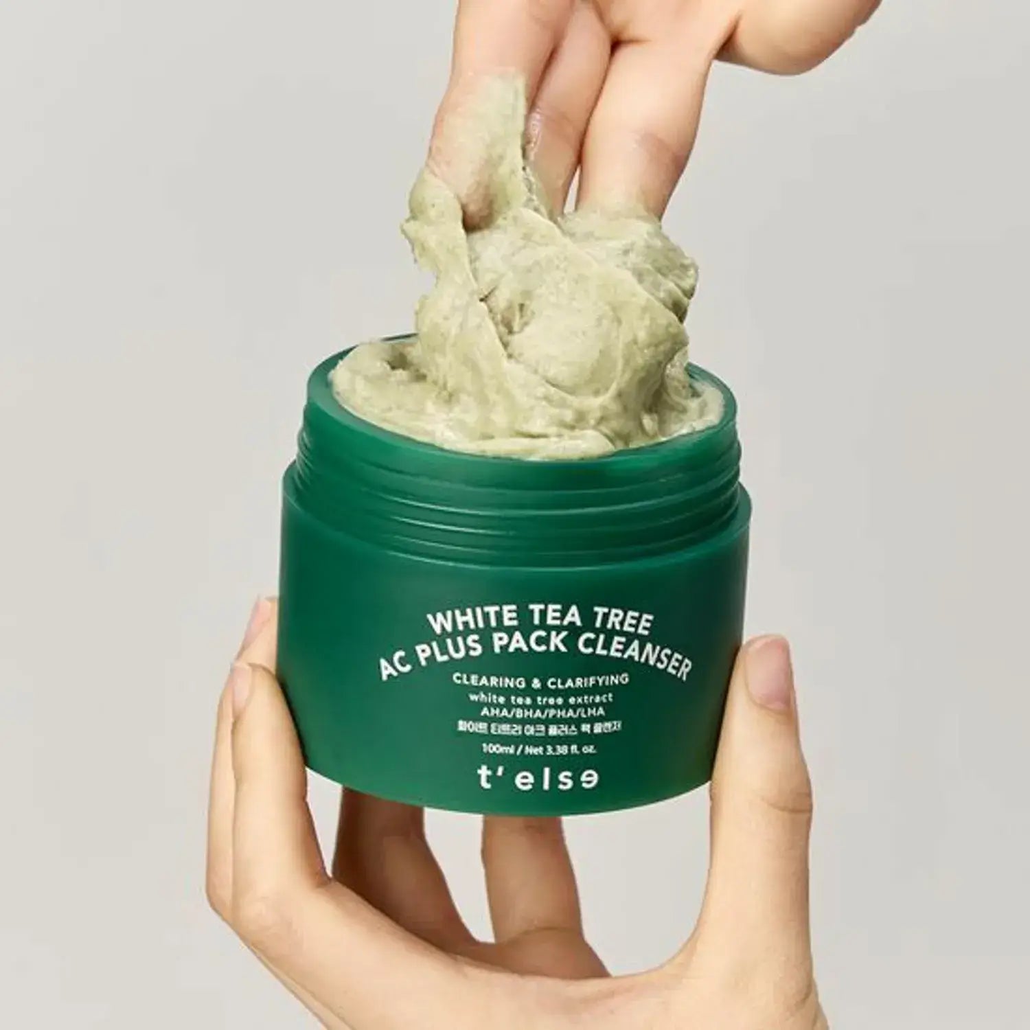 Person holding open jar of T'ELSE White Tea Tree Arc Plus Pack Cleanser 100ml with product on fingers.