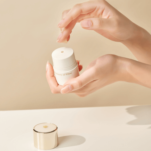 Hands applying THE WHOO Royal Essential Golden Lip Serine 15ml on a light background.