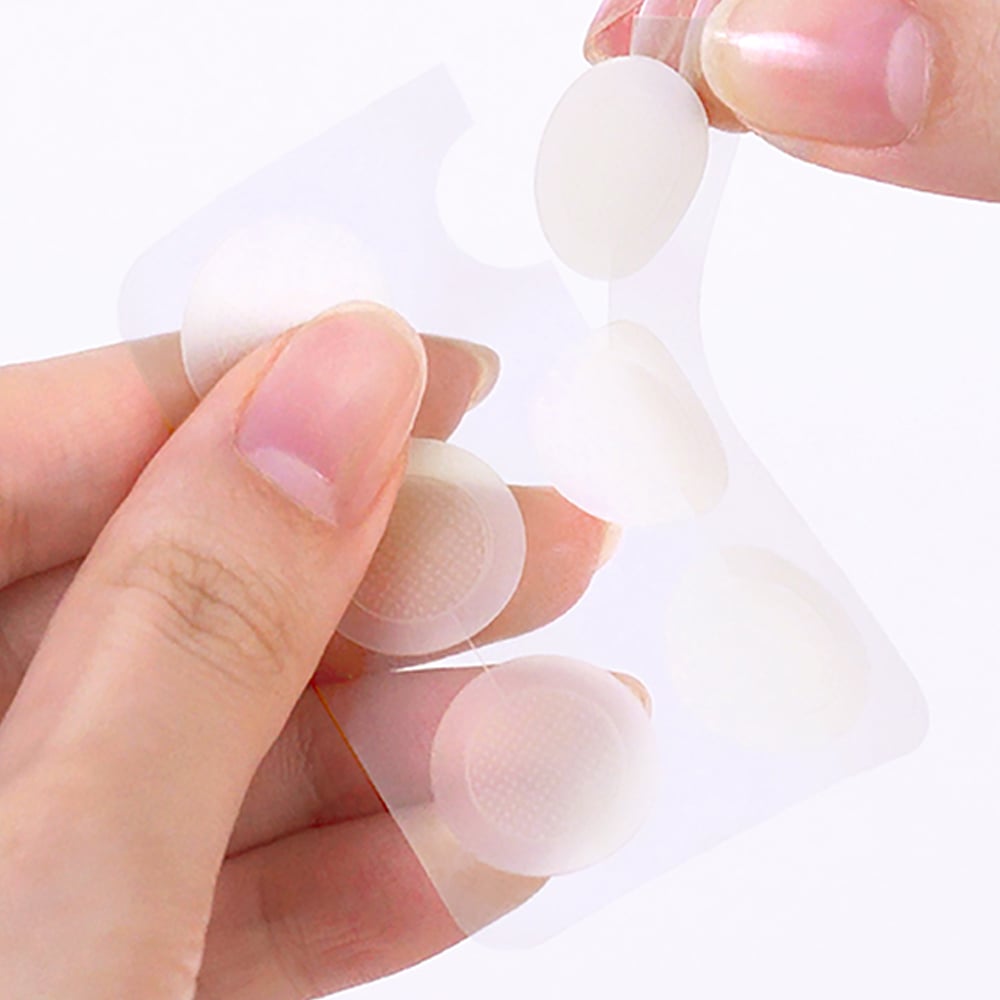 Person holding THE SAEM Golden Berry C Dark Spot Patch with transparent circular patches in hand.