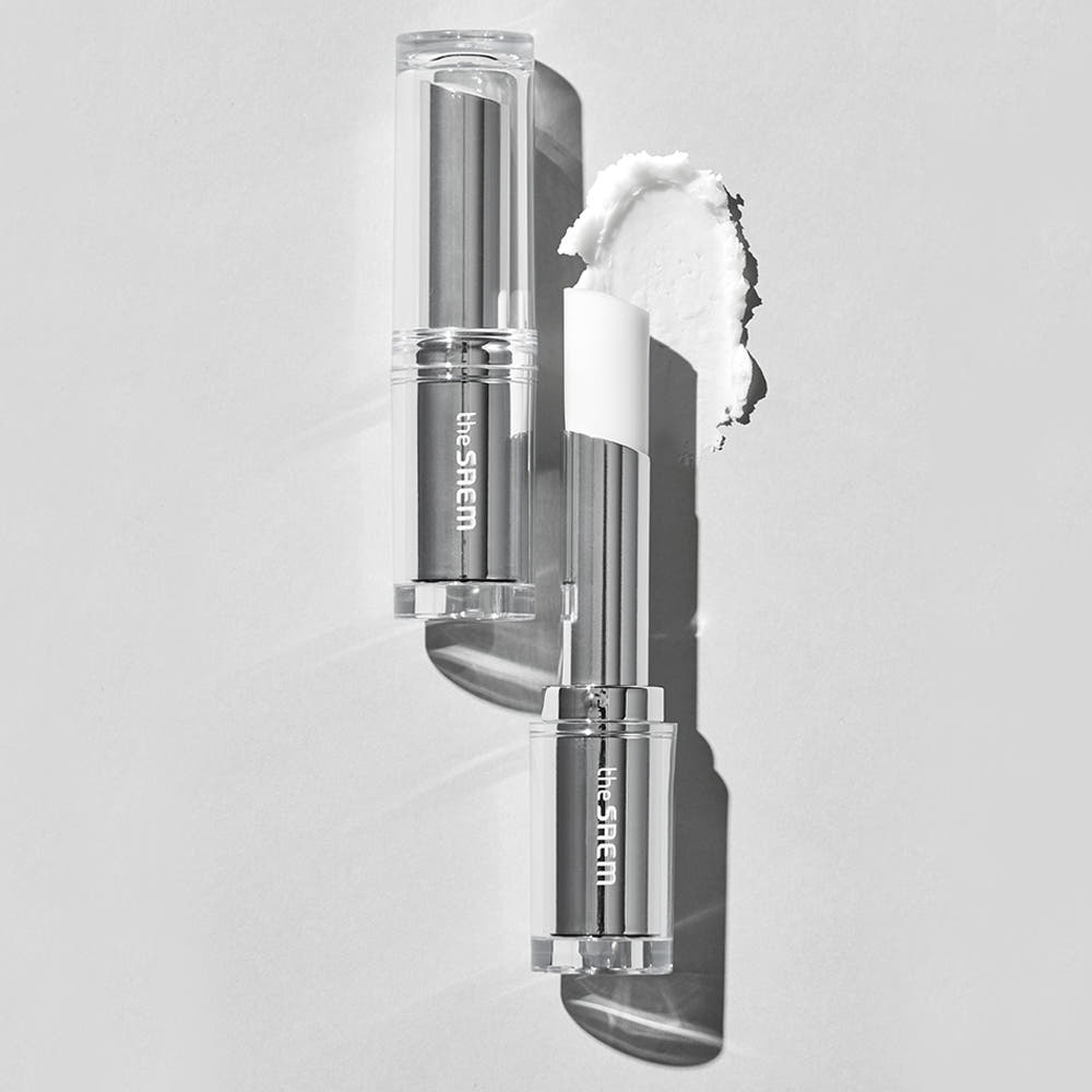 THE SAEM Soft Blurring Primer Lip Balm in clear packaging on monochrome background, showcasing texture and color.