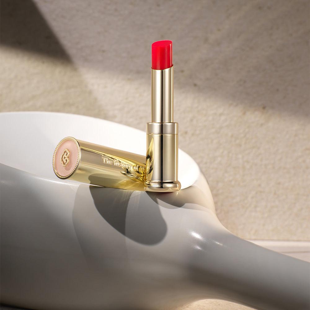 THE WHOO Gong Jin Hyang Mi Glow Lip Balm 3.3g in a sleek gold case on a reflective surface