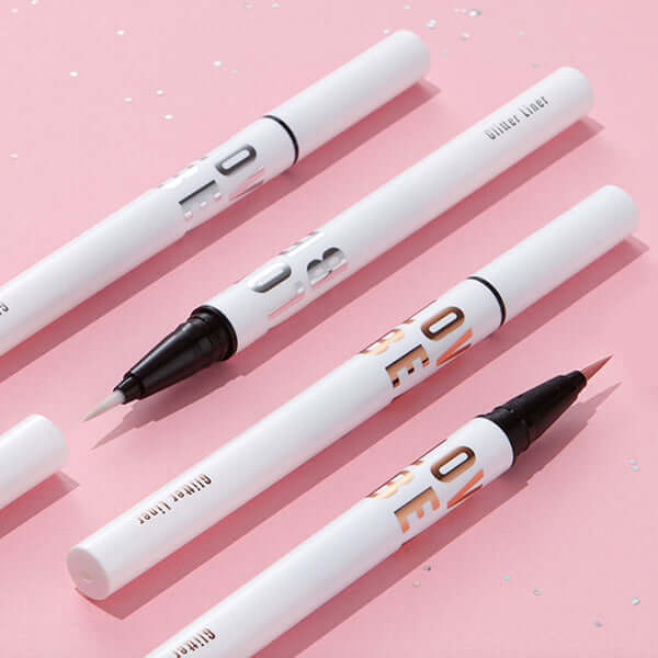 TONY MOLY Aegyo Beam Glitter Liner displayed on a pink background with silver glitter accents, highlighting precision tips.