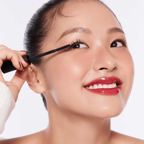 Woman applying TONY MOLY Eyetone Curl Correcting Mascara for enhanced lashes and curl definition.