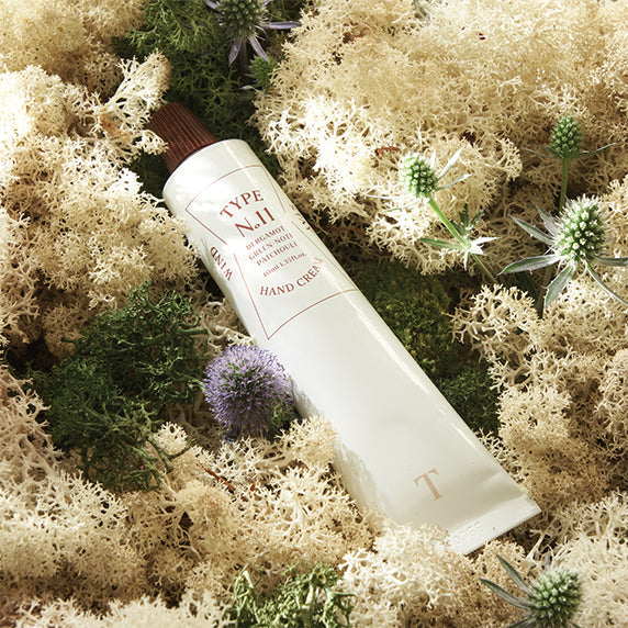 TYPE NO. No.11 Wind Stay Handcream 40ml tube placed on a natural moss background for a soothing skincare presentation.