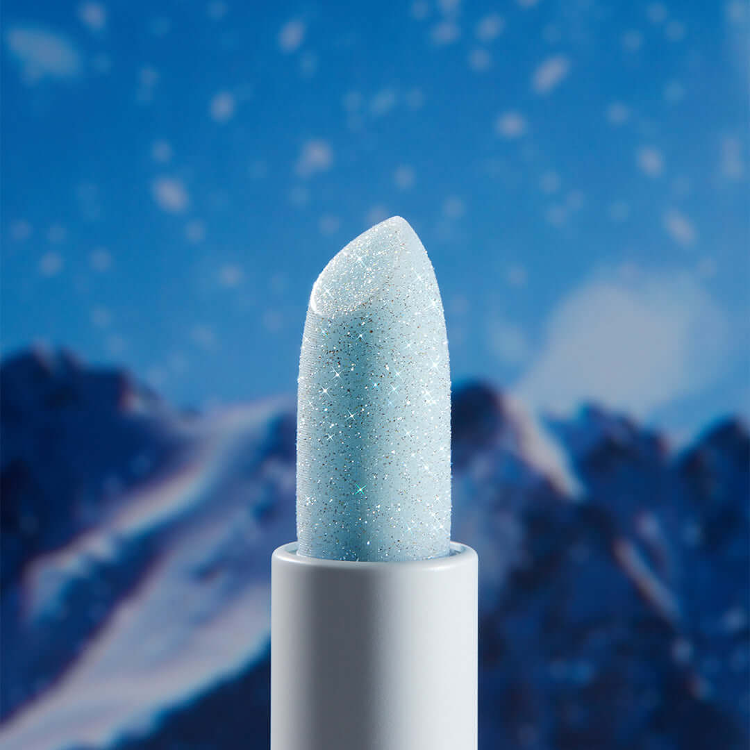 UNLEASHIA Glacier Vegan Lip Balm against a snowy mountain backdrop