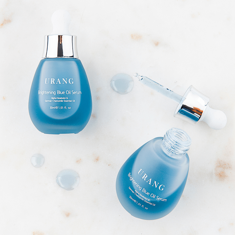 URANG Brightening Blue Oil Serum 30ml bottles and dropper on a marble surface