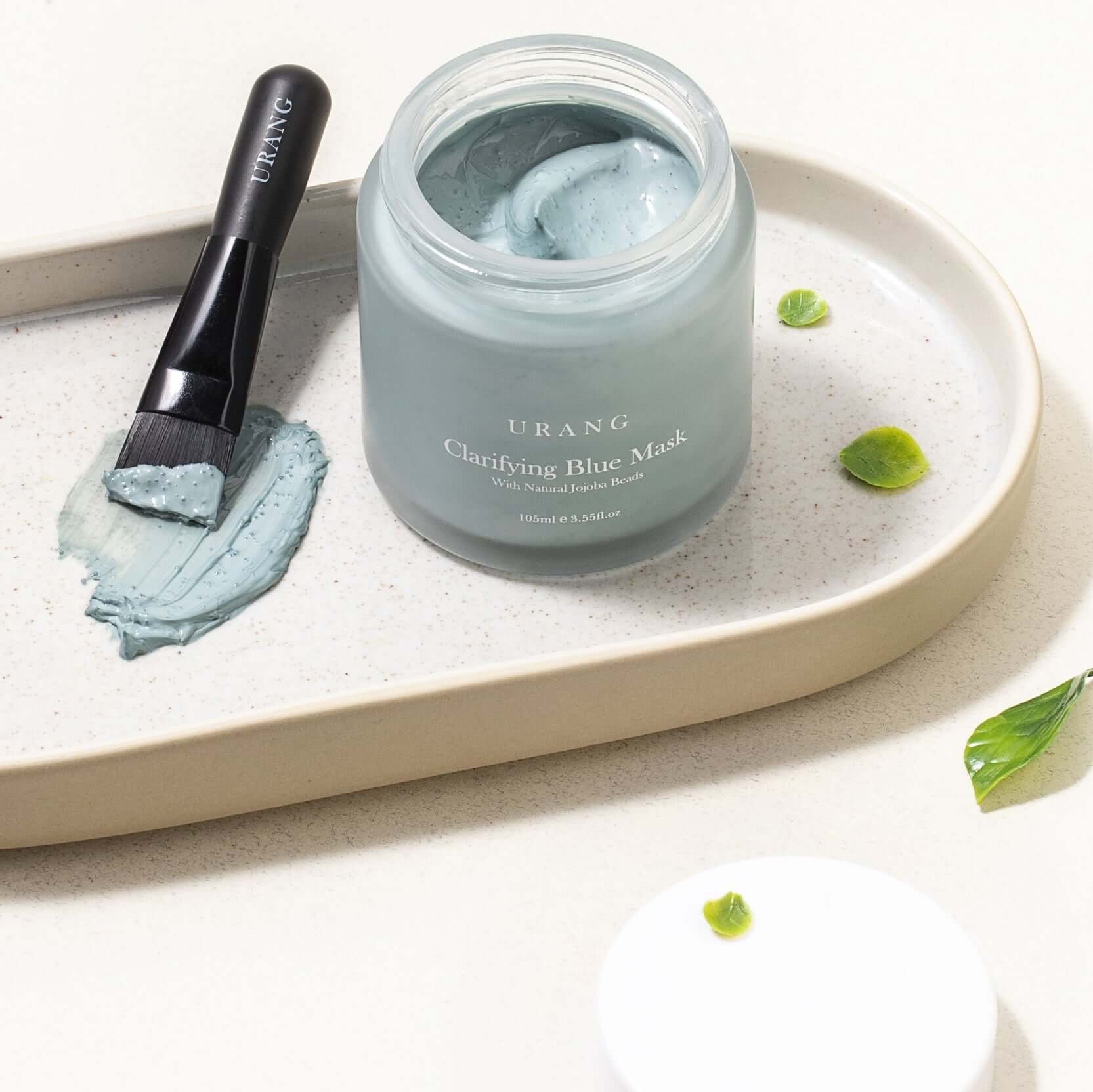 URANG Clarifying Blue Mask with applicator brush on a tray, showcasing skincare product.