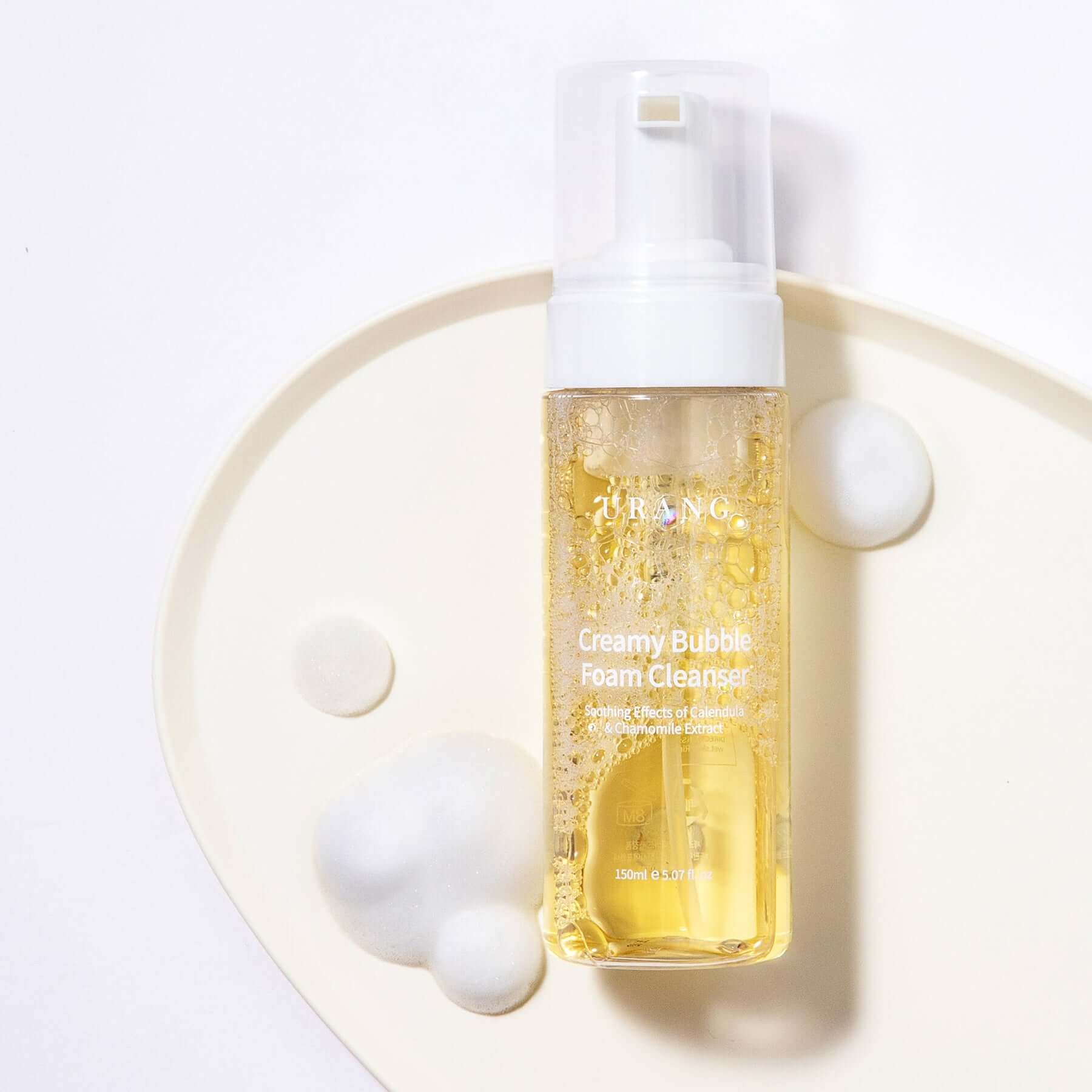 URANG Creamy Bubble Foam Cleanser 150ml bottle with foam on a white tray.