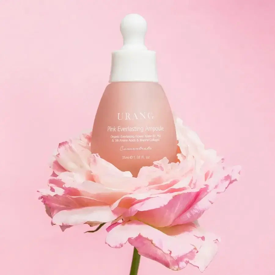 URANG Pink Everlasting Ampoule displayed on a pink rose background, beauty skincare product in elegant packaging.