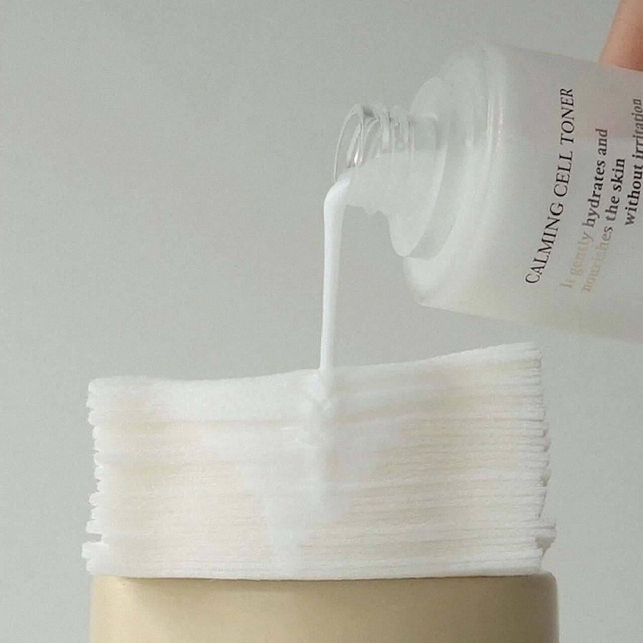 XOUL Calming Cell Toner 130ml being poured onto cotton pads for soothing skincare routine