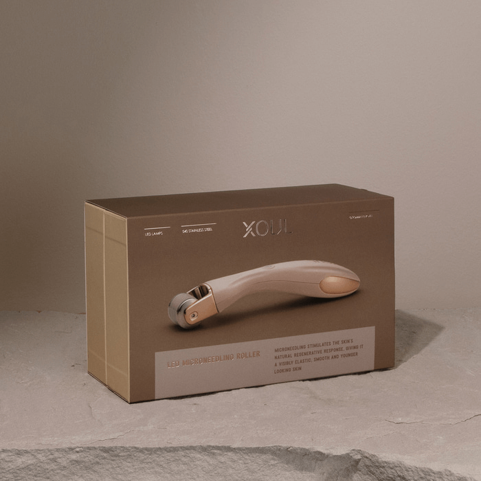 XOUL MTS Microneedle Device in packaging on stone surface, designed for skincare enhancement and youthful appearance