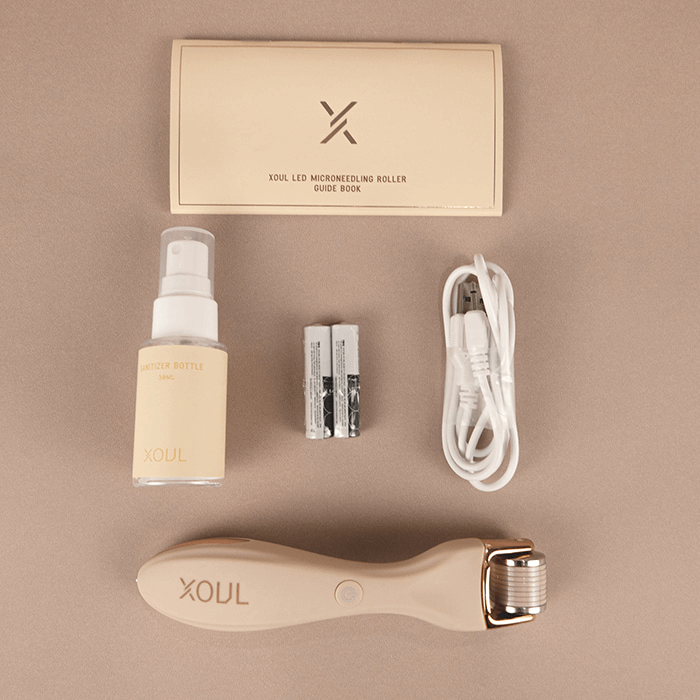 XOUL MTS Microneedle Device with accessories including manual, sanitizer bottle, batteries, USB cable, and dermaroller.