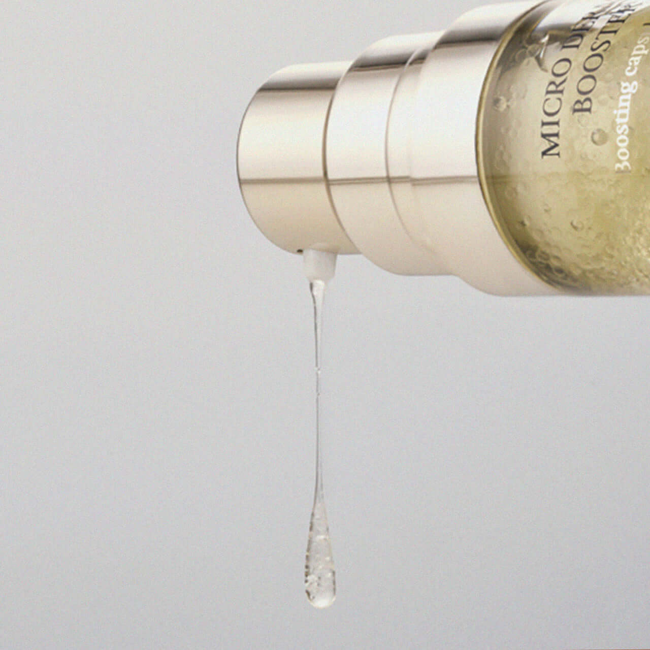 XOUL Micro Derma Booster 30ml serum drop detail showcasing product texture and luxurious packaging.