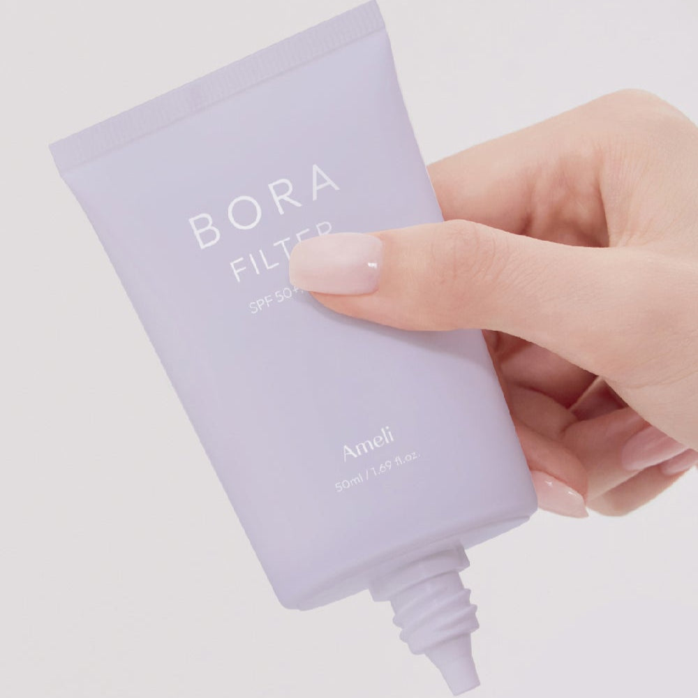 Person holding AMELI Complement Series Bora Filter 50ml tube.