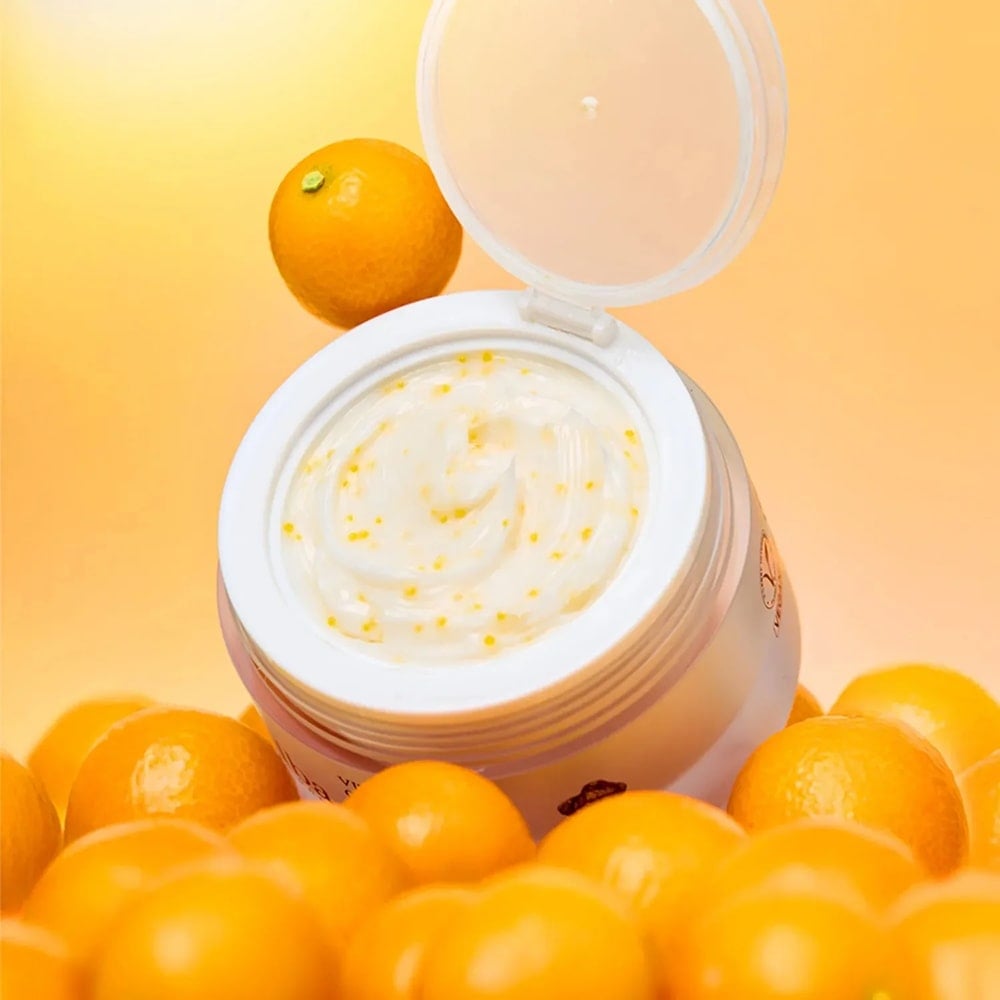 Open jar of D'ALBA Vita Toning Capsule Cream Complex 55g surrounded by fresh oranges on a vibrant background