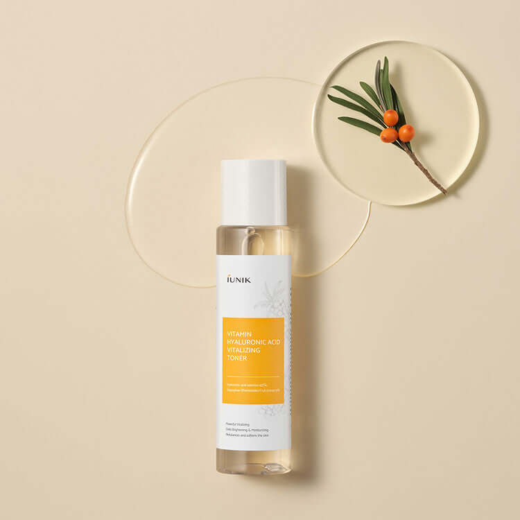 iUNIK Vitamin Hyaluronic Acid Vitalizing Toner 200ml bottle with sea buckthorn fruit on beige background