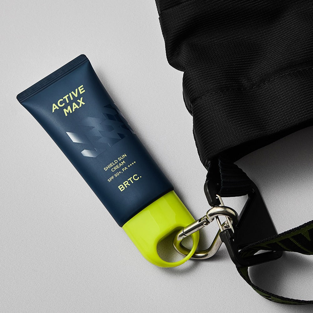 BRTC Homme Active Max Sheild Sunscreen 50ml - Gentleman Korea product image of navy tube with lime cap clipped to a black bag