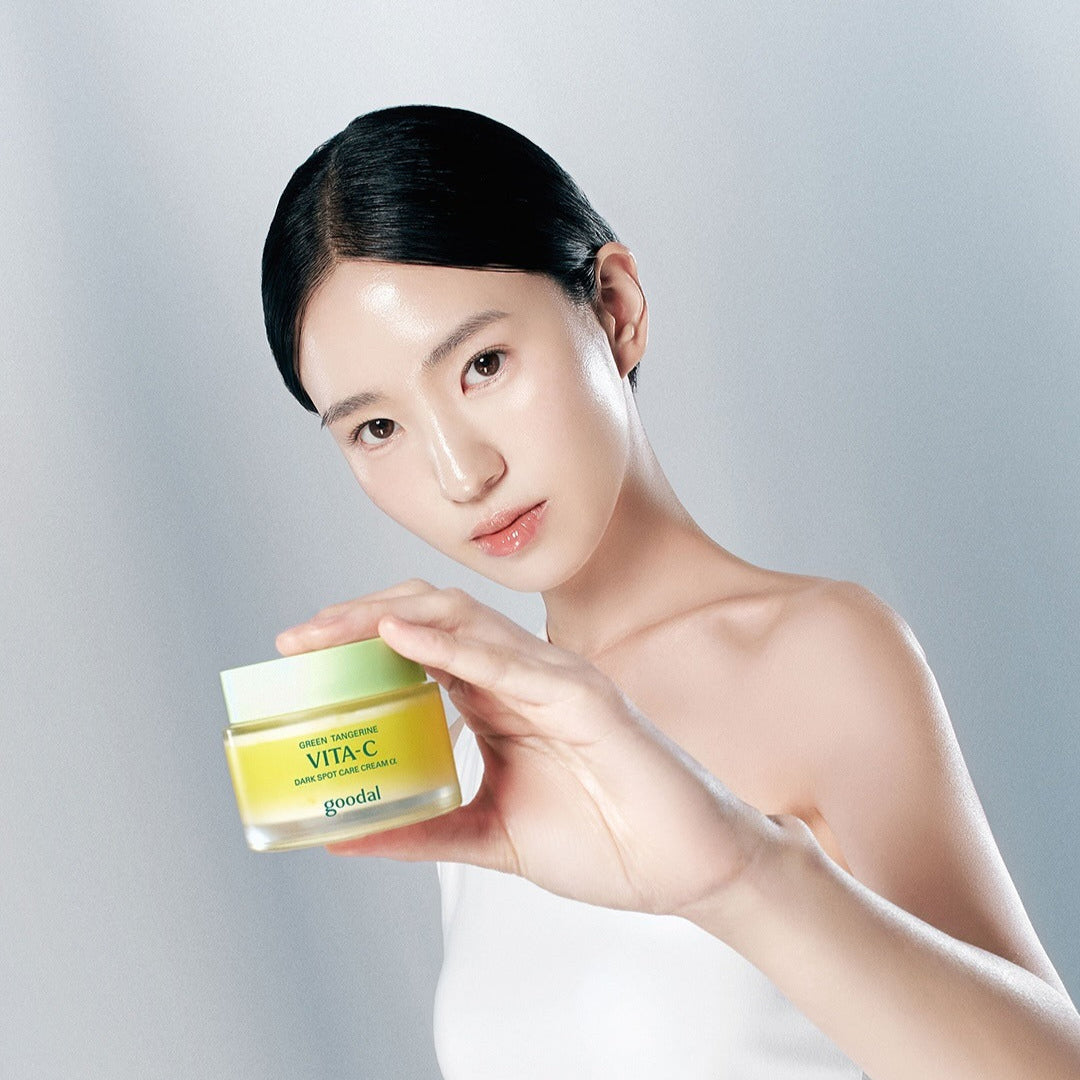 Woman holding GOODAL Green Tangerine Vita C Spot Care Cream Alpha 75ml jar in hand.