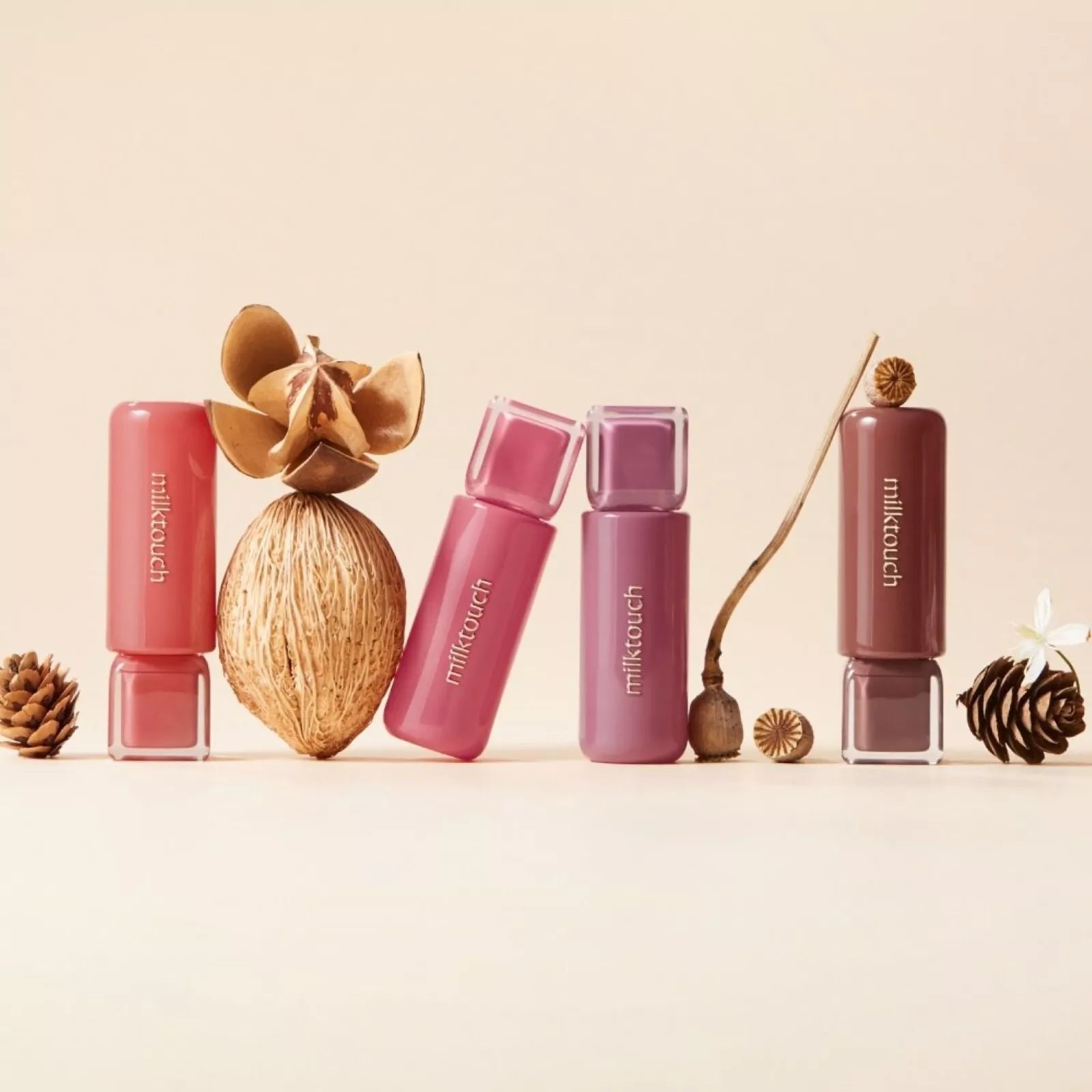 MILK TOUCH Jelly Fit Tinted Glow Tint products displayed with natural elements like pinecones and dried flowers.