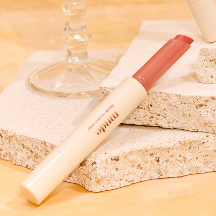 MUDE Drizzle Night lip product on stone surface