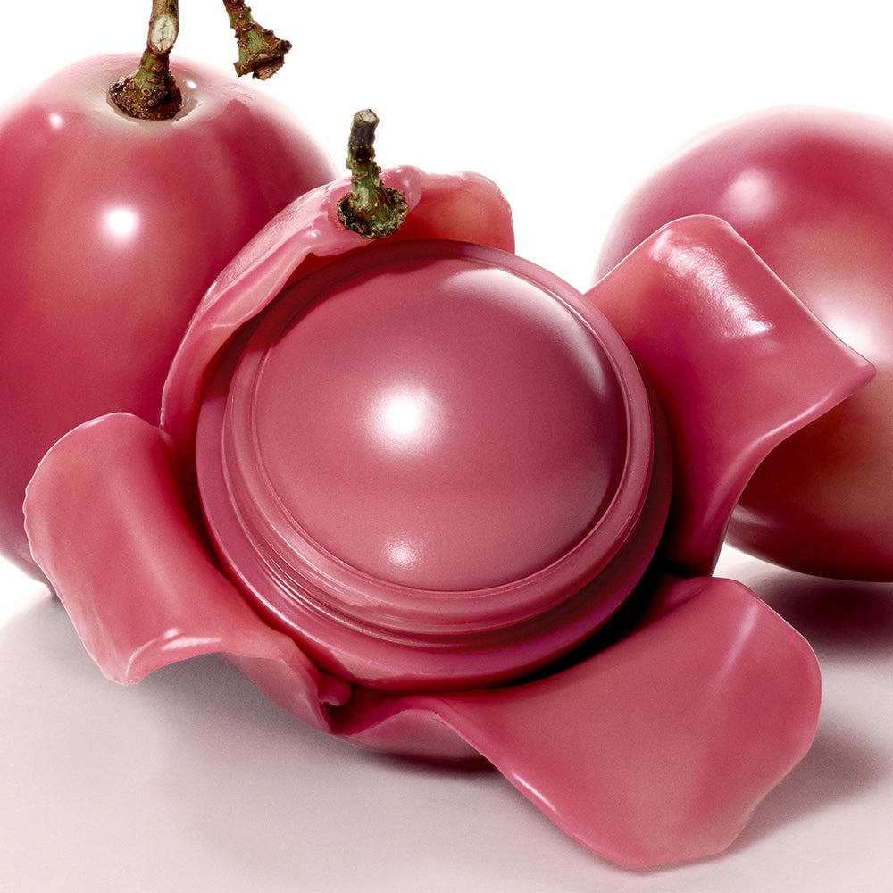 ROMAND Juicy roll cheek with rosy pink hue nestled in vibrant petals