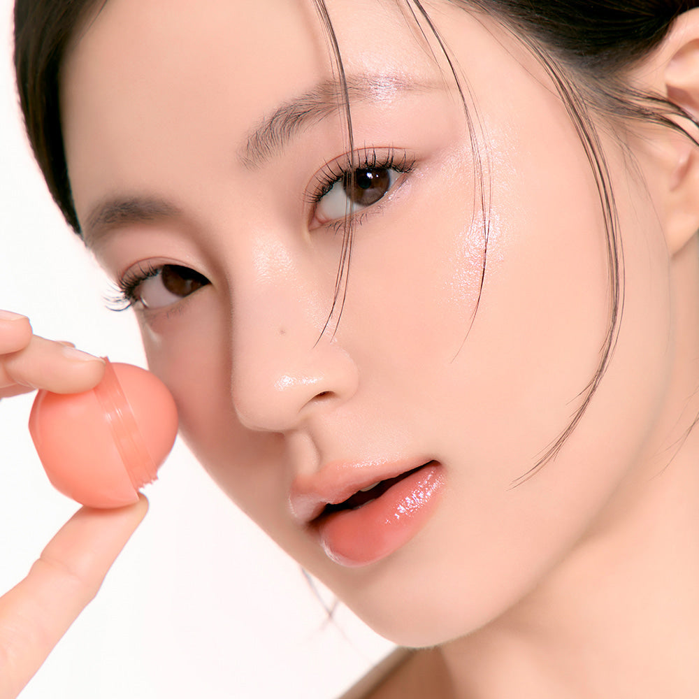 Woman applying ROMAND Juicy roll cheek blush for a fresh look
