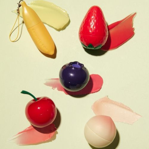 TONY MOLY MIN Fruit Lip Balm collection featuring various fruit shapes including banana, strawberry, cherry, and purple grape on beige.