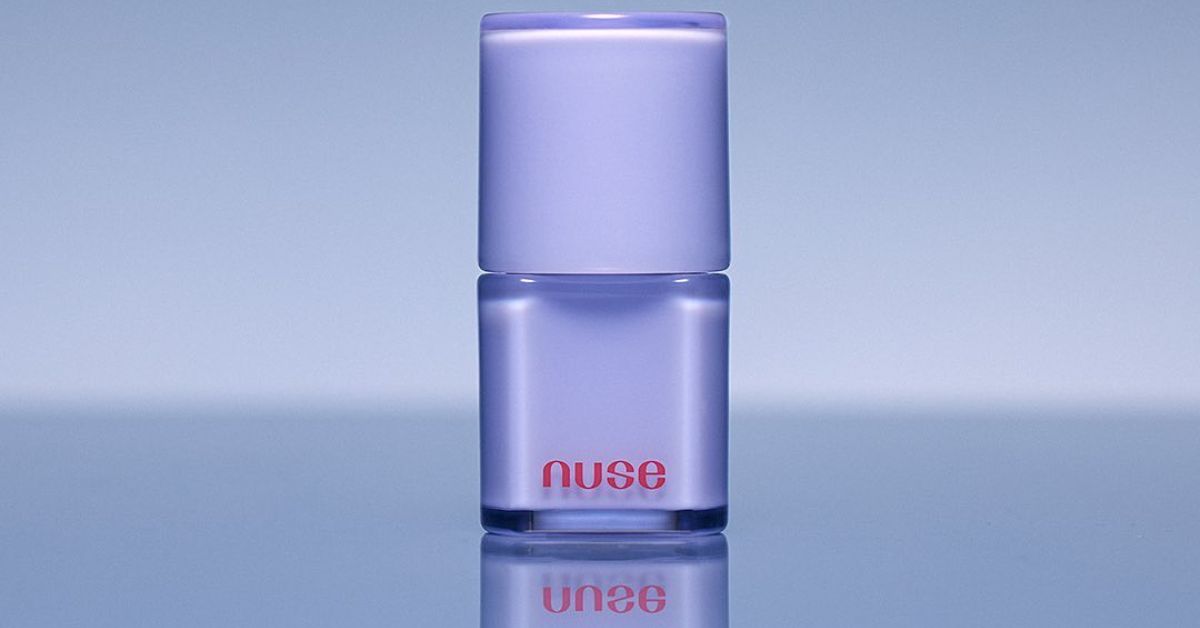 NUSE: Dive into a World of Fun and Glam with Our Groundbreaking Makeup Line! Elegant lavender makeup bottle on reflective surface.
