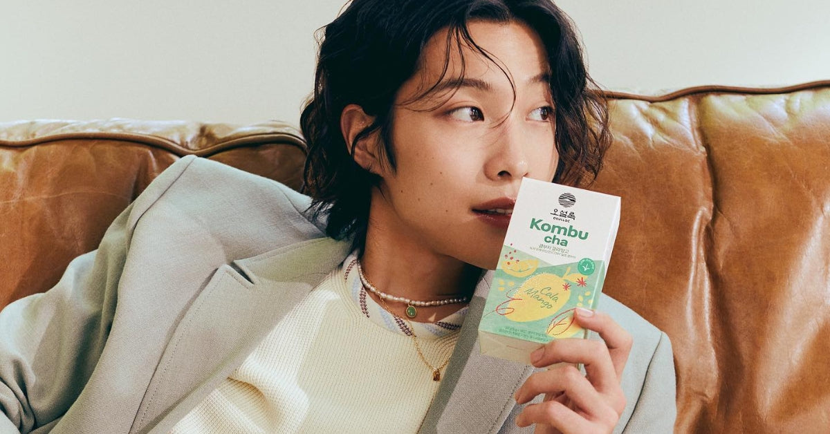 Person enjoying OSULLOC Kombucha, embodying 'Sip, Savor, and Soar: Dive into Korea’s Rich Tea Culture with OSULLOC' experience.