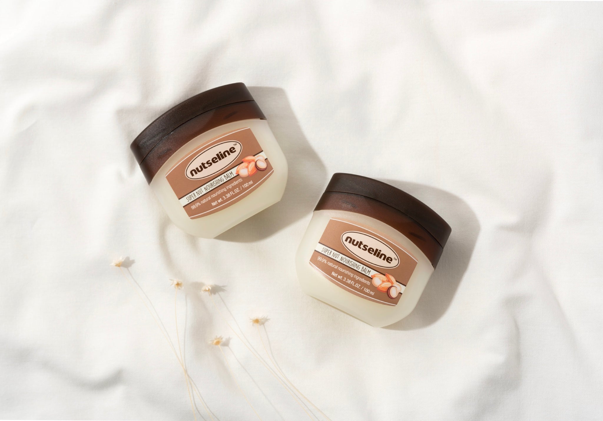 NUTSELINE skincare tubs on white fabric, highlighting top products to revitalize your skin.