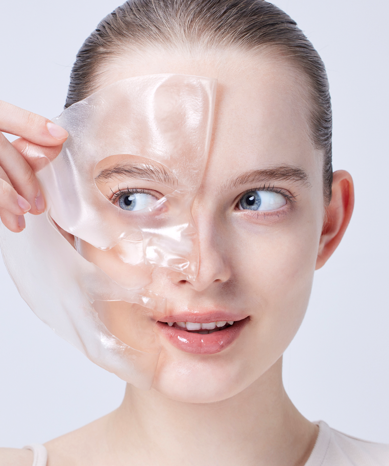 Woman applying COSRX The Alpha-Arbutin Discoloration Care Hydrogel Mask (3EA) to her face, showing skincare application process.