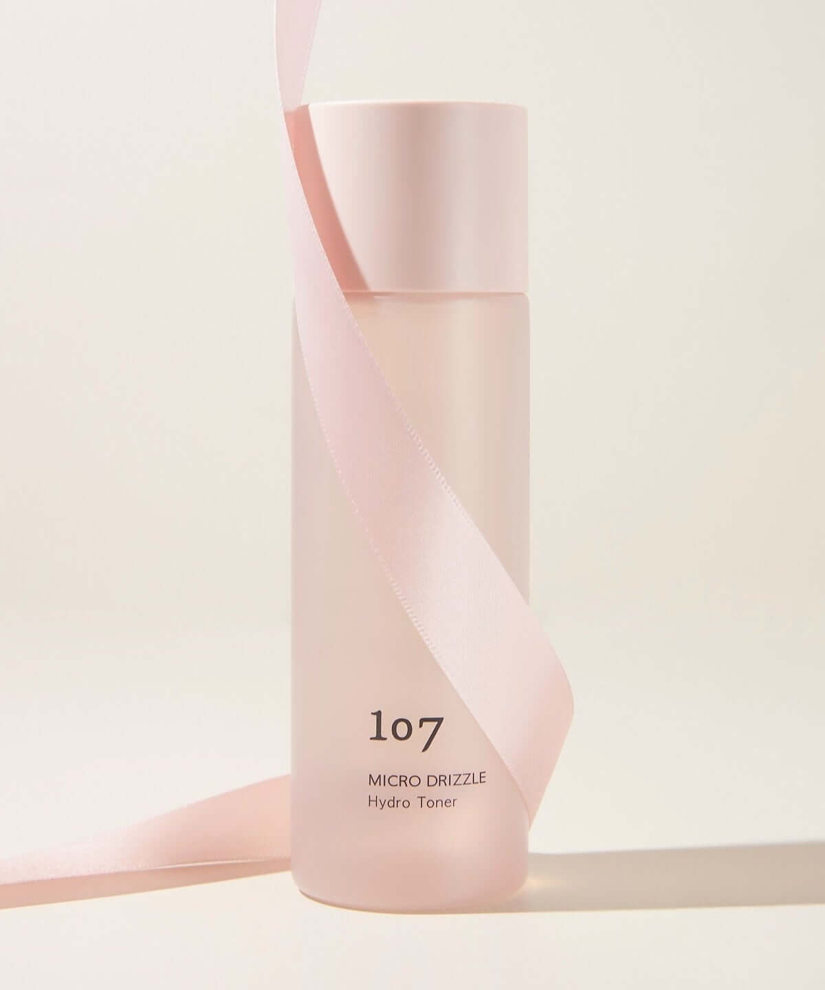 107 Micro Drizzle Hydro Toner 155ml bottle with pink ribbon, elegant skincare packaging