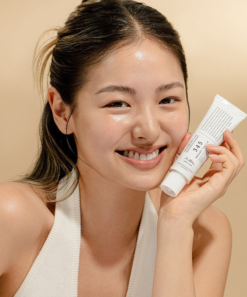 Smiling person holding DR ALTHEA 345 Relief Cream, showcasing skincare results
