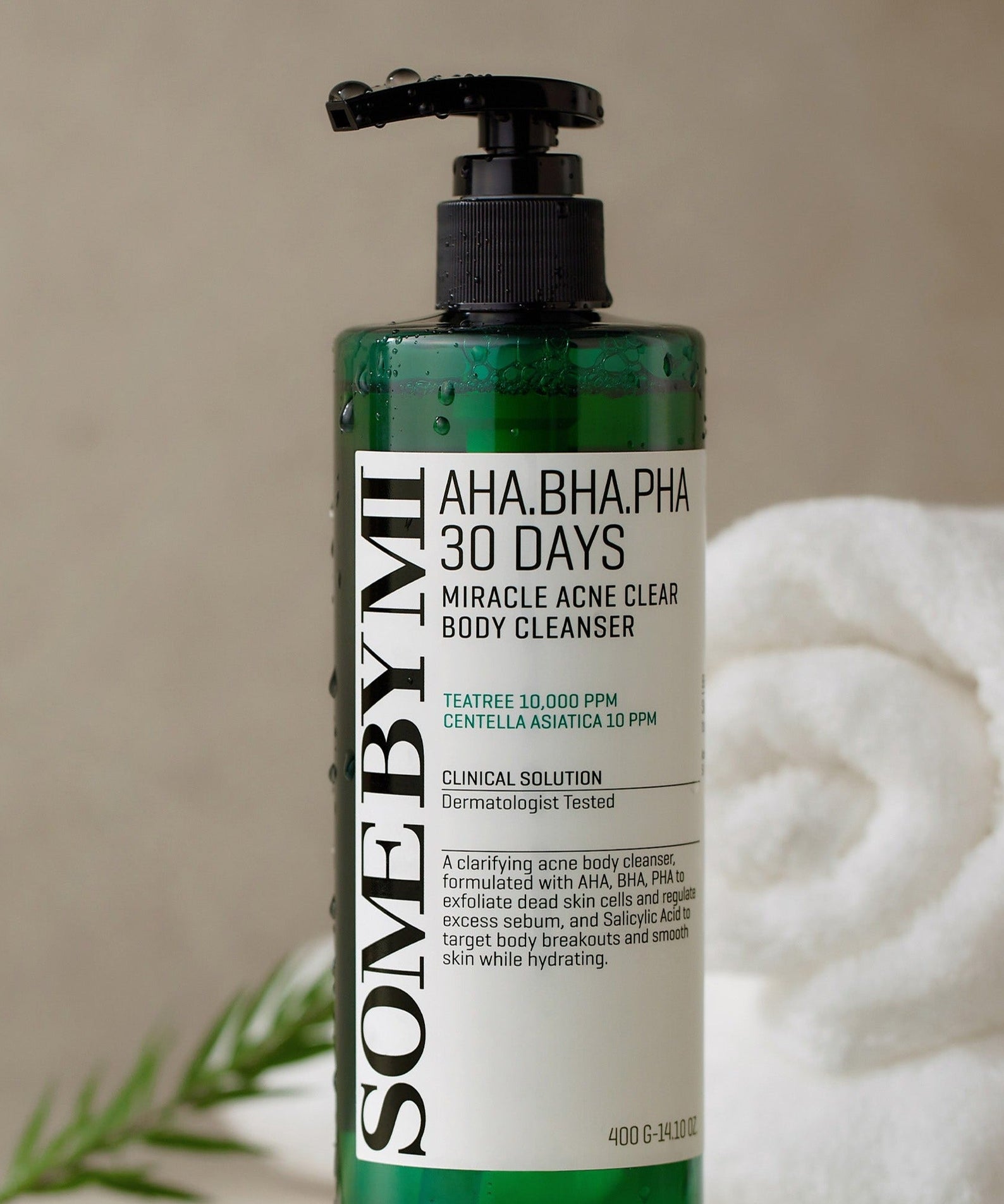 SOME BY MI AHA.BHA.PHA Miracle Acne Clear Body Cleanser 400g bottle next to white towels and greenery.