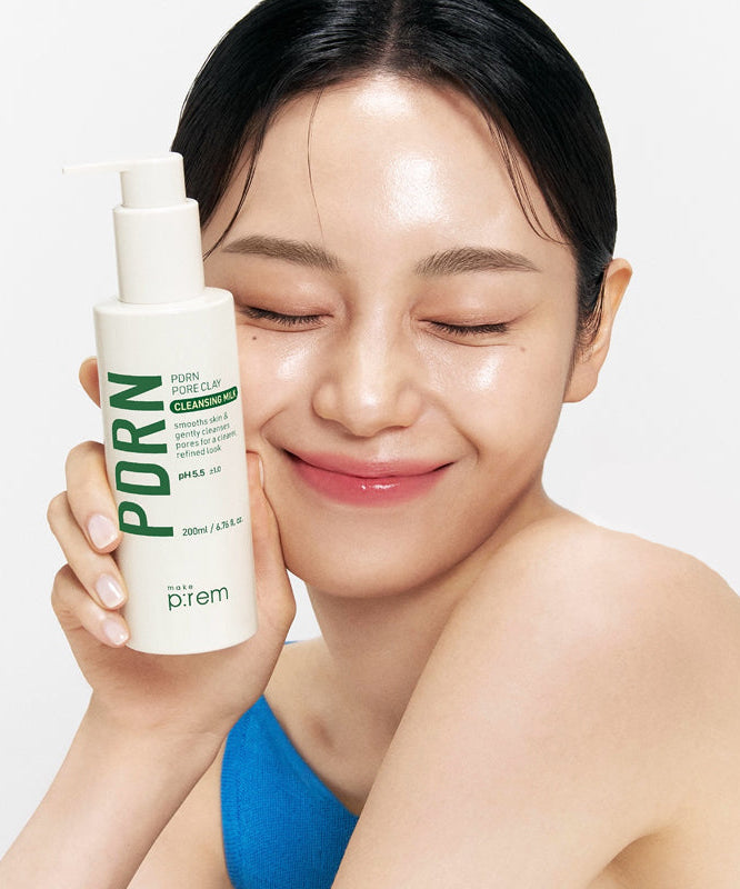 Woman holding a bottle of MAKE P:REM PDRN Pore Clay Cleansing Milk 500ml with a smile