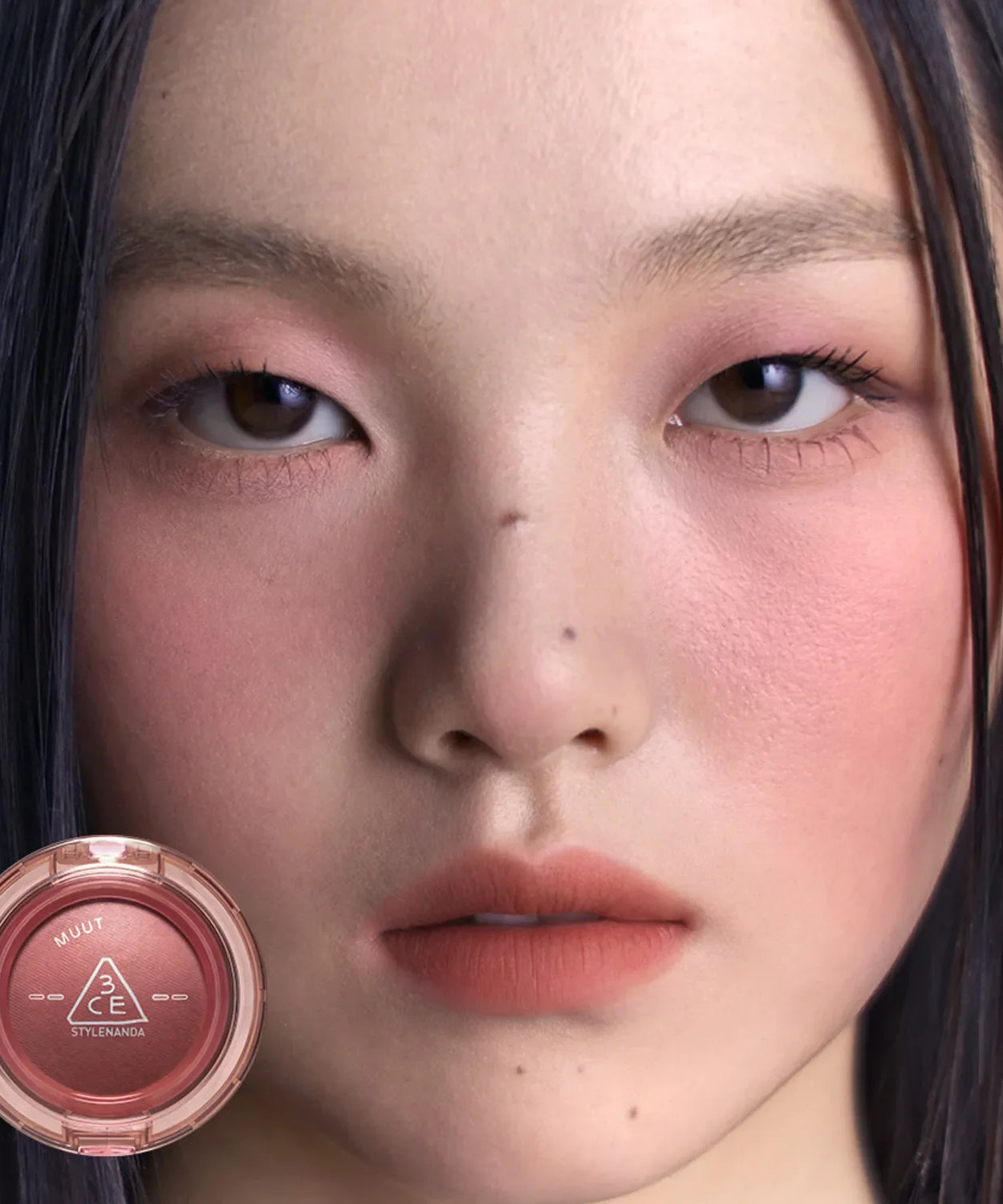 Close-up of model wearing makeup with 3CE Bouncy Blur Balm showcased in a round compact for smooth, flawless skin finish.