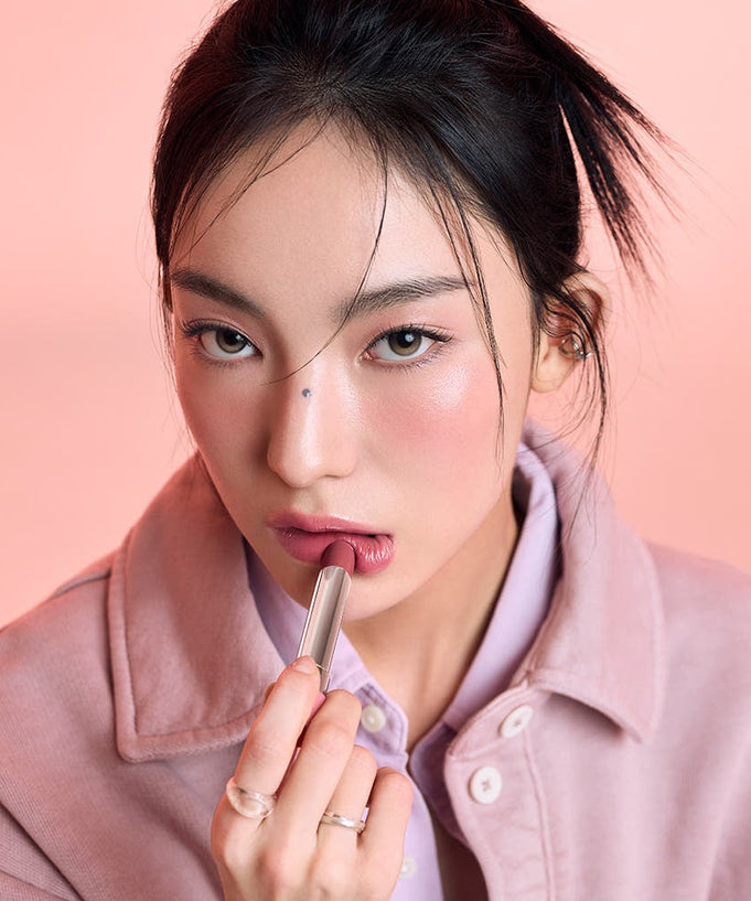 Model applying 3CE Glaze Lip Glow 3.2g, showcasing vibrant lip color and smooth texture, perfect for trendy makeup looks.