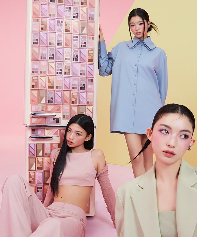 Fashion models posing in pastel outfits in front of a colorful backdrop with makeup palettes on shelves.