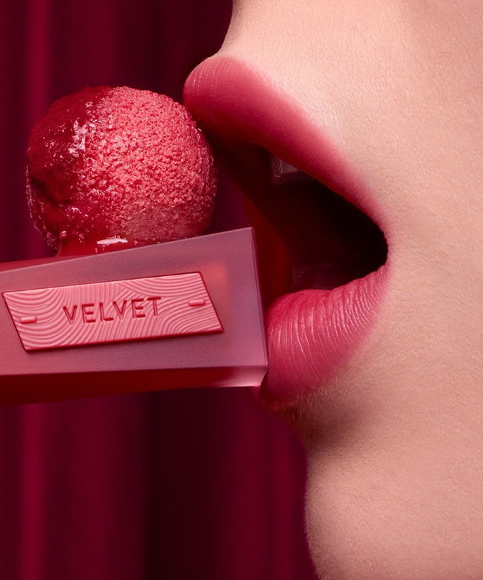 Close-up of model applying 3CE Velvet Lip Tint Plush for vibrant lip color