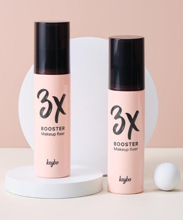 KEYBO 3X Booster Make Up Fixer 100ml displayed on white platform with pink background