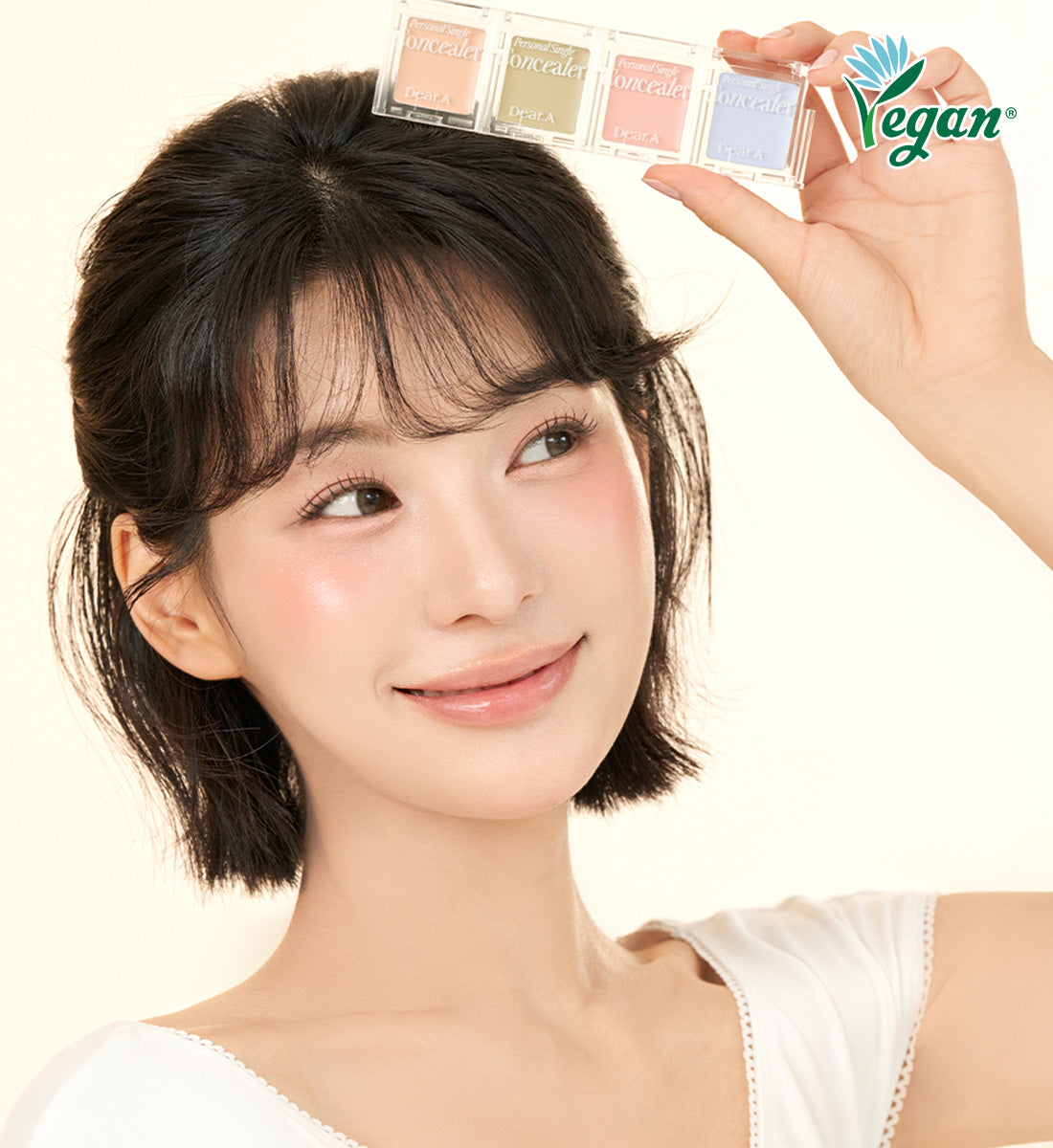 Woman holding DEAR.A Single Concealer 10 Colors with vegan logo.