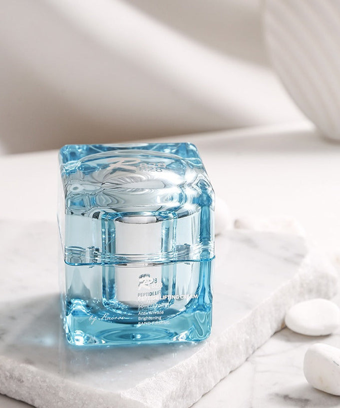 R828 Peptide Lifting Cream in elegant glass container on marble surface, skincare product