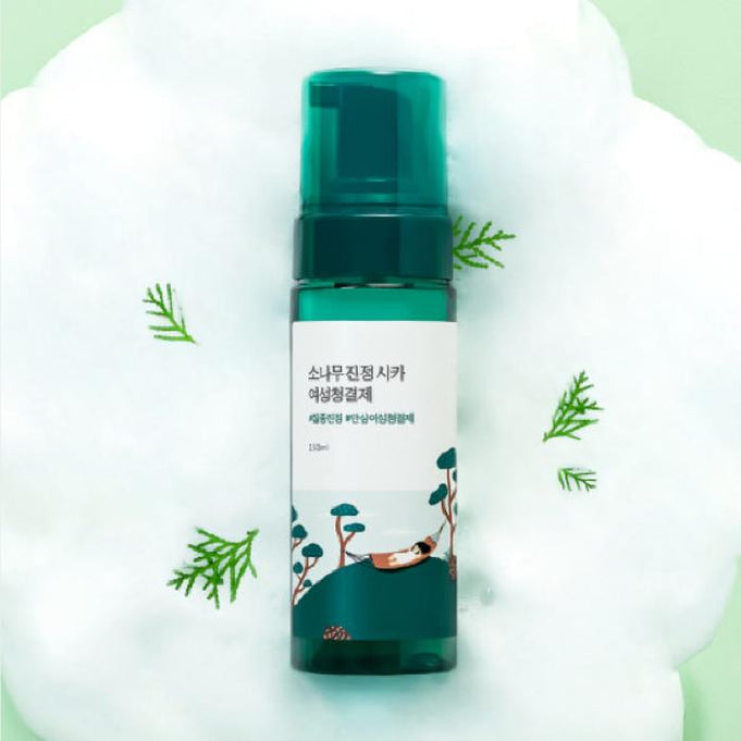 ROUND LAB Pine Calming Cica Body Mist 150ml bottle surrounded by pine leaves on a fluffy white background.