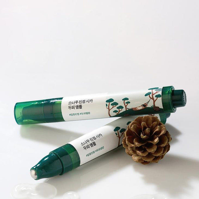 Two tubes of ROUND LAB Pine Soothing Cica Scalp Ampoule 15ml with pine cone on white background