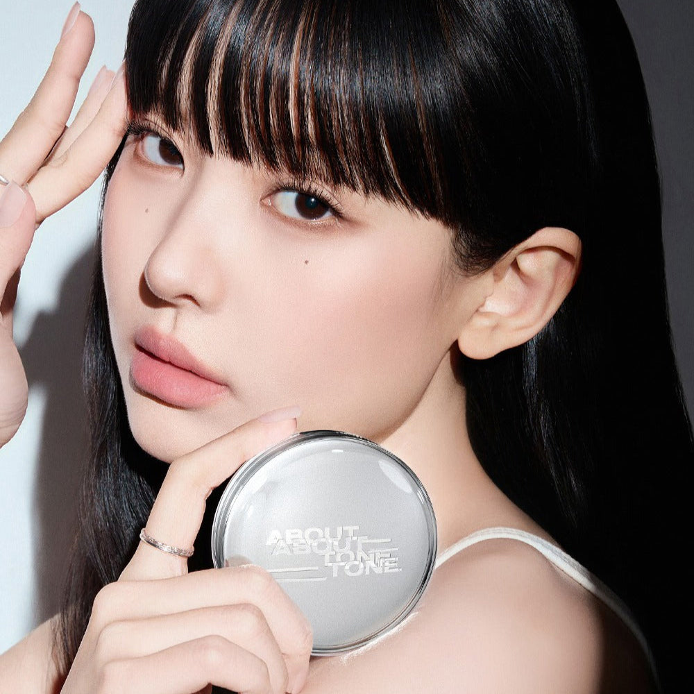 Woman holding ABOUT TONE Skin Layer Fit Cushion, showcasing the product's design and compact size.