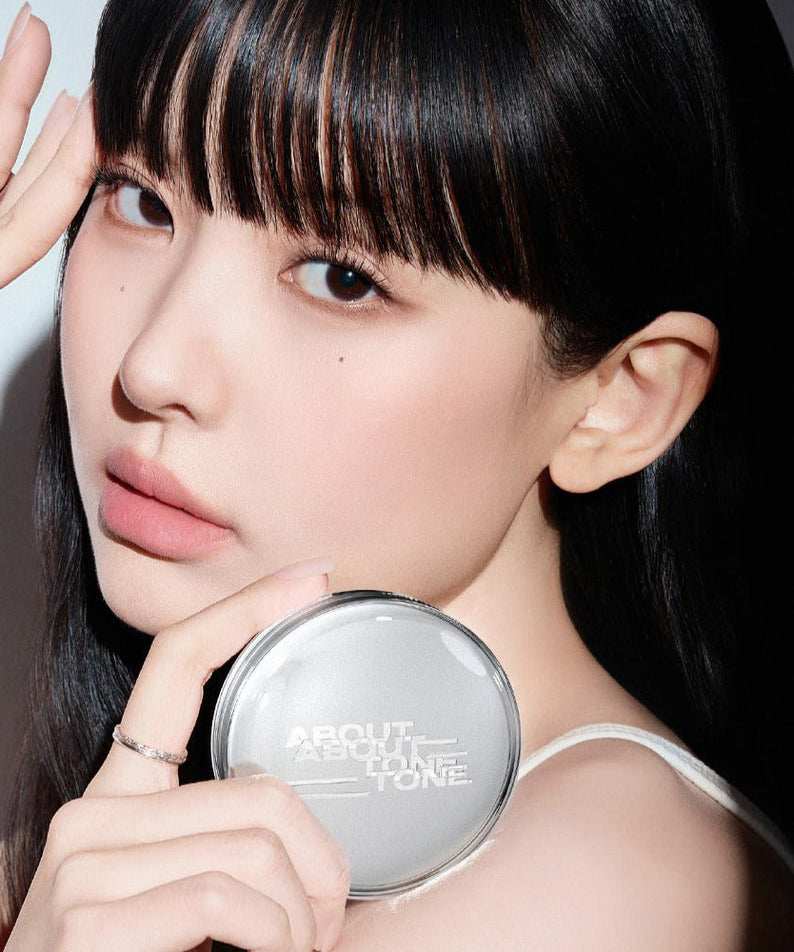 Woman holding ABOUT TONE Skin Layer Fit Cushion, showcasing the product's design and compact size.