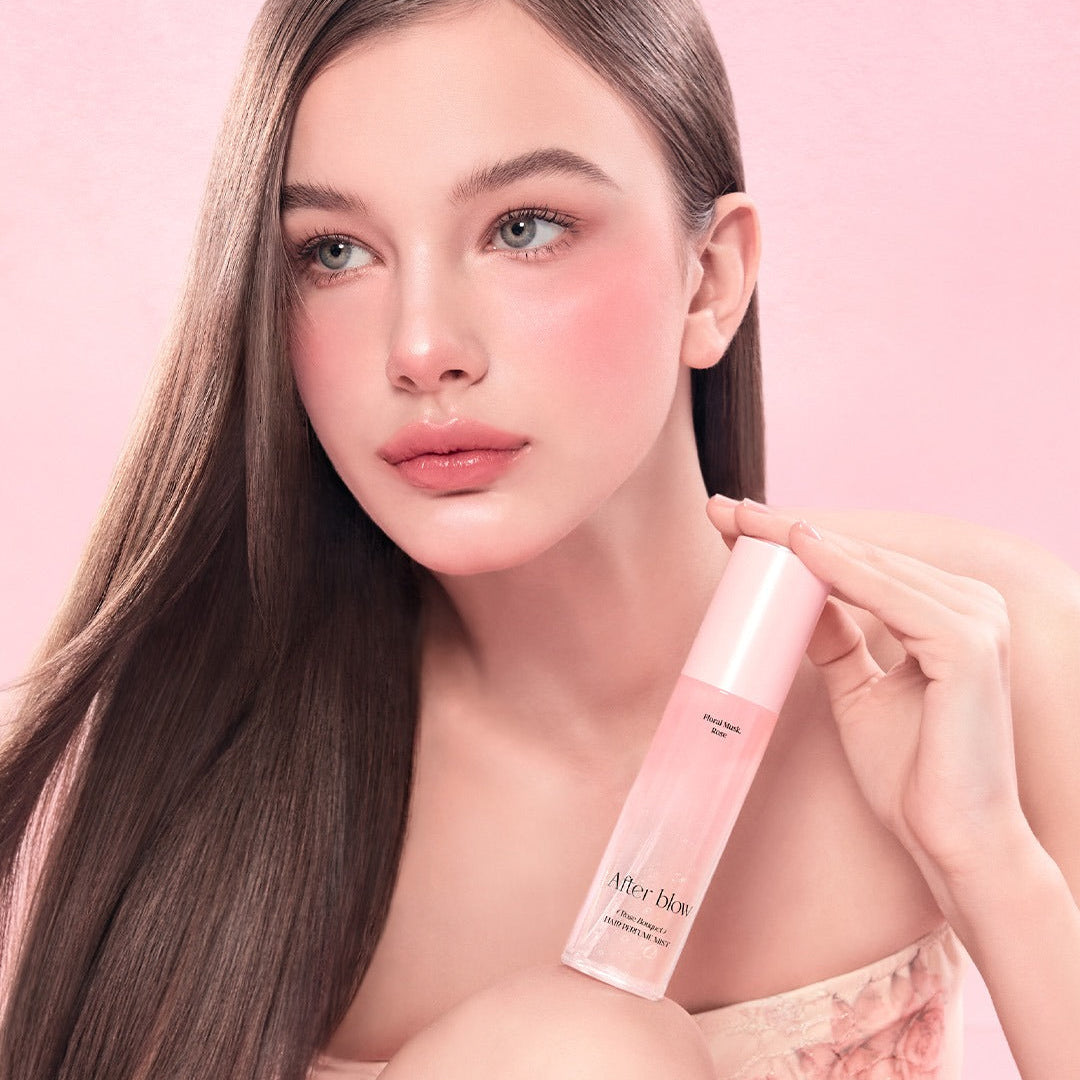 Model holding AFTER BLOW Hair Perfume Mist 80ml with pink background.