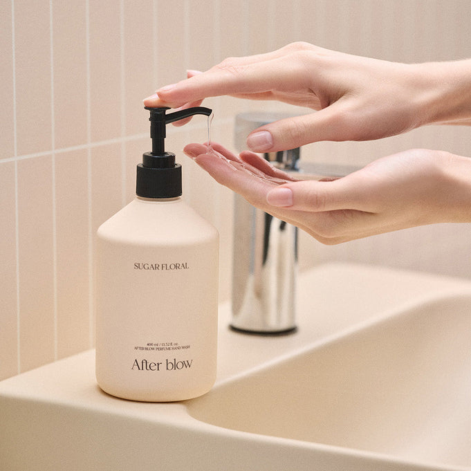 Hands using AFTER BLOW Perfume Hand Wash Sugar Floral 400ml by a sink.